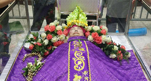 Ante a proibição de enterrar o Bispo com sua mitra, fiéis o ornam com uma de mitra de flores